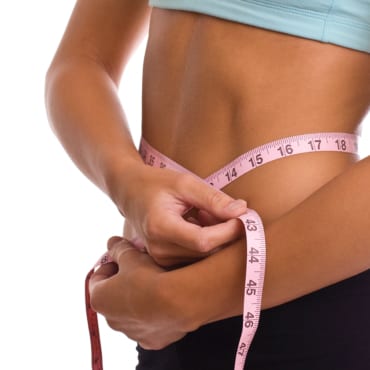 A woman measuring weight loss from Discover Chiropractic